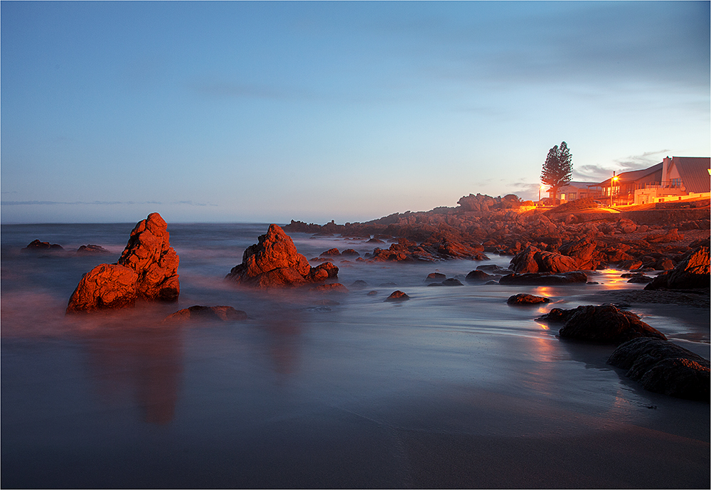Stunning coastal sunset view with luxury accommodation overlooking the rocky Hermanus coastline